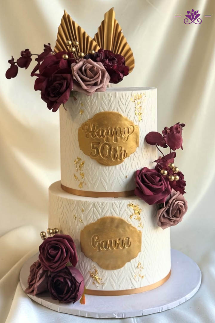 Elegant two-tier white, burgundy and gold cake