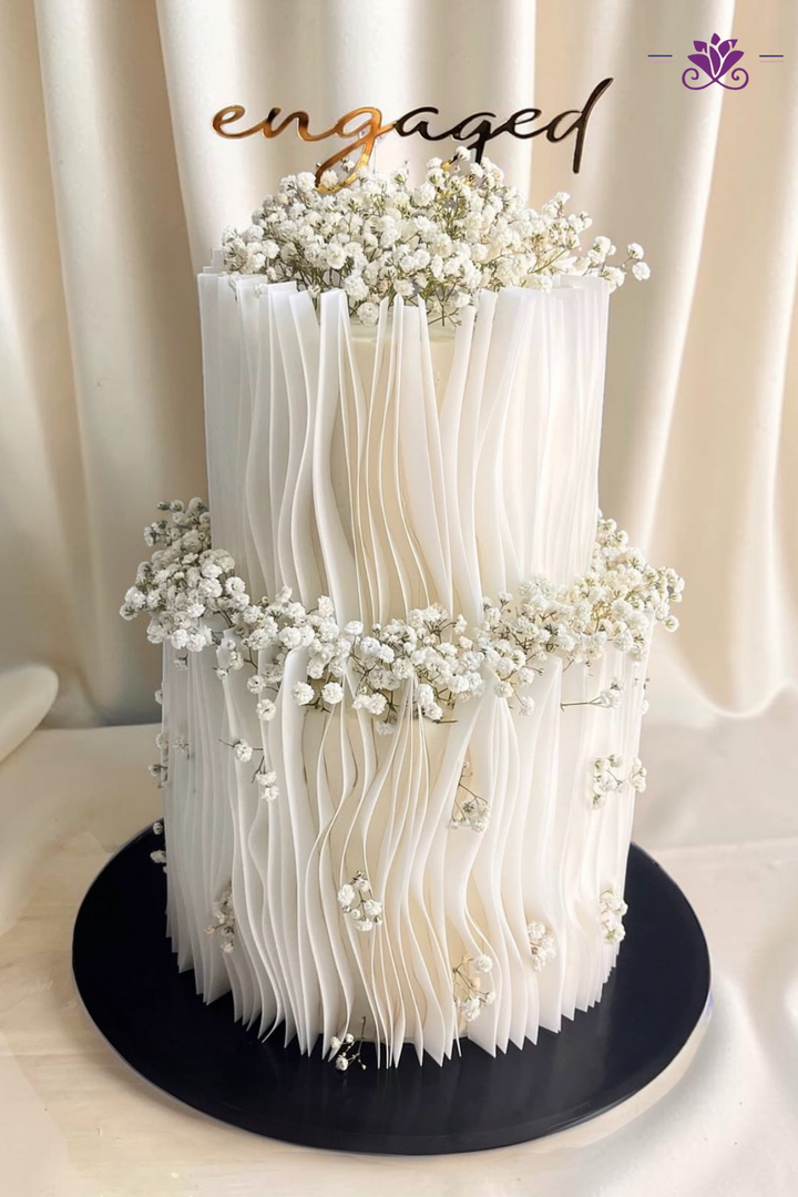 Beautiful white birthday cake with stylish gold candles.